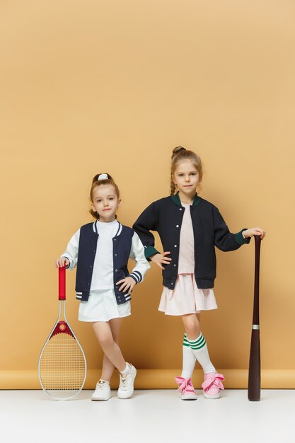 Retrato de dos chicas como tenistas con raqueta de tenis.