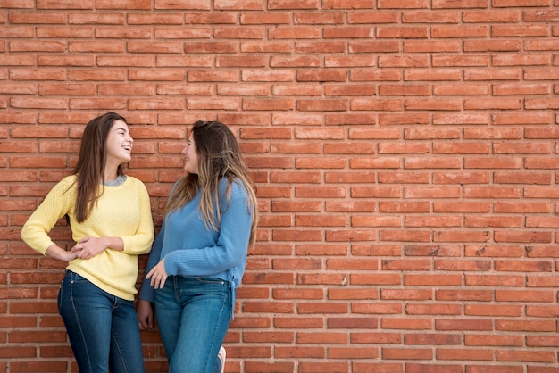 Retrato de dos chicas enfrente de un muro