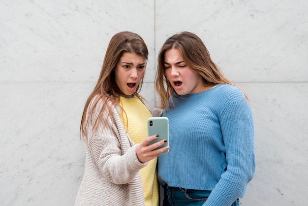 Retrato de dos chicas enfrente de una pared