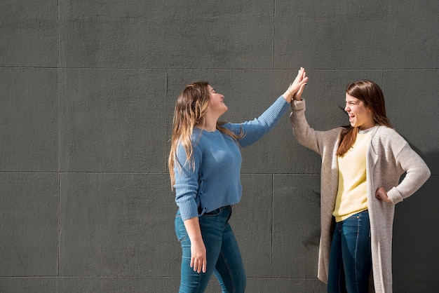 Foto gratuita retrato de dos chicas enfrente de una pared