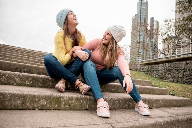 Retrato de dos chicas en entorno urbana pasándoselo bien