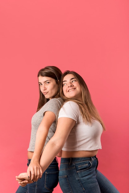 Foto gratuita retrato de dos chicas sobre fondo rojo