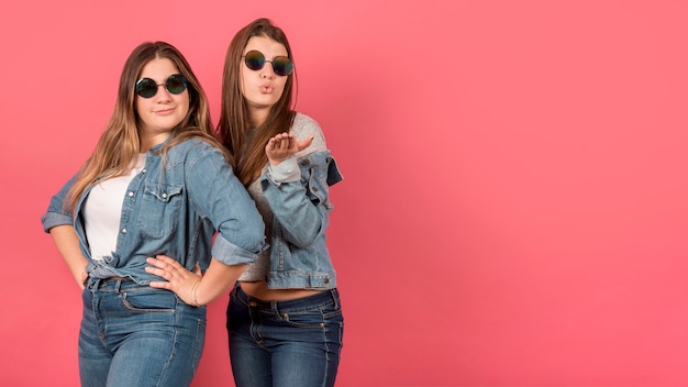 Retrato de dos chicas sobre fondo rojo