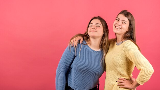 Foto gratuita retrato de dos chicas sobre fondo rojo