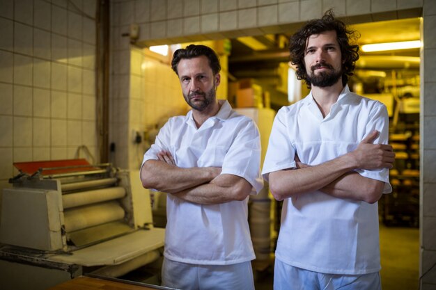 Retrato de dos cocineros pie en la cocina de la panadería