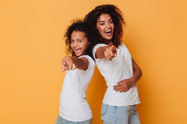 Retrato de dos hermanas africanas sonrientes de pie de espaldas