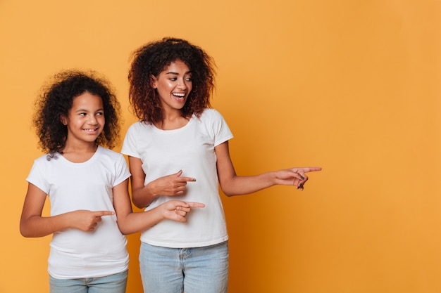 Retrato de dos hermanas afroamericanas felices señalando