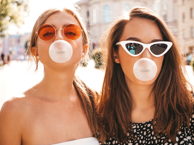Retrato de dos jóvenes hermosas chicas hipster sonrientes en ropa de moda de verano