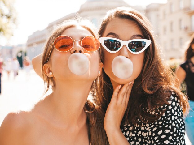 Retrato de dos jóvenes hermosas chicas hipster sonrientes en ropa de moda de verano