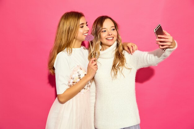 Retrato de dos jóvenes mujeres rubias sonrientes con estilo