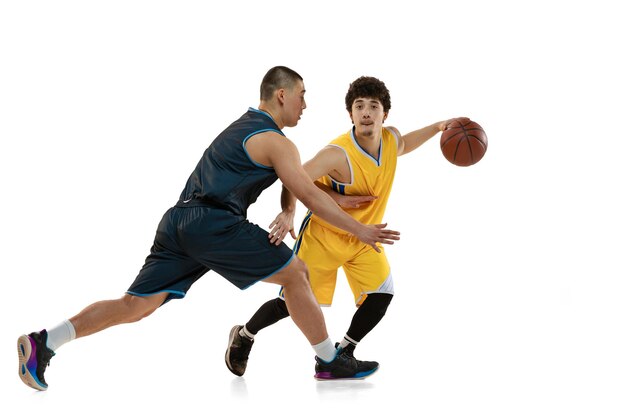 Retrato de dos jugadores de baloncesto entrenando regates aislados sobre fondo blanco de estudio