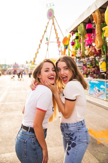 Retrato de dos mujeres que se ríen en el parque de atracciones