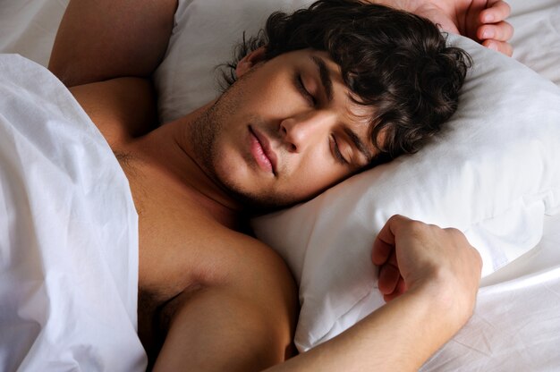 Retrato de un dulce joven durmiendo hermoso hombre acostado de espalda