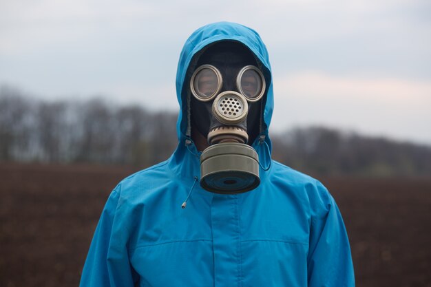 Retrato de ecologista trabajando al aire libre, con máscara de gas y uniforme, el científico explora los alrededores, el científico trabaja al aire libre