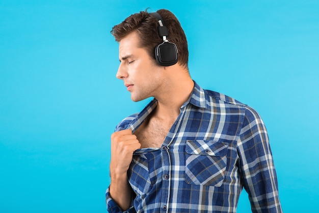 Retrato de elegante atractivo joven guapo escuchando música en auriculares inalámbricos divirtiéndose estilo moderno feliz estado de ánimo emocional