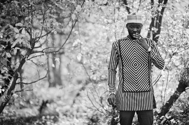 Retrato de un elegante hombre afroamericano negro con sombrero contra el soleado fondo de otoño