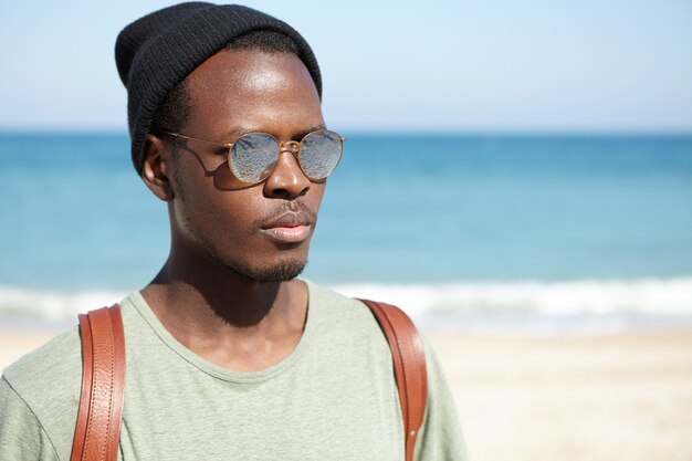 Retrato de elegante hombre afroamericano en la playa