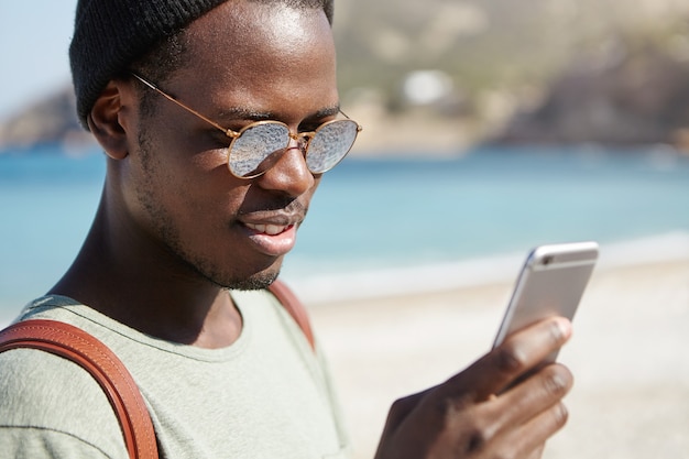 Retrato de elegante hombre afroamericano en la playa