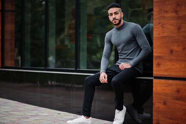 Retrato de un elegante hombre de barba árabe que usa un modelo árabe de cuello alto gris