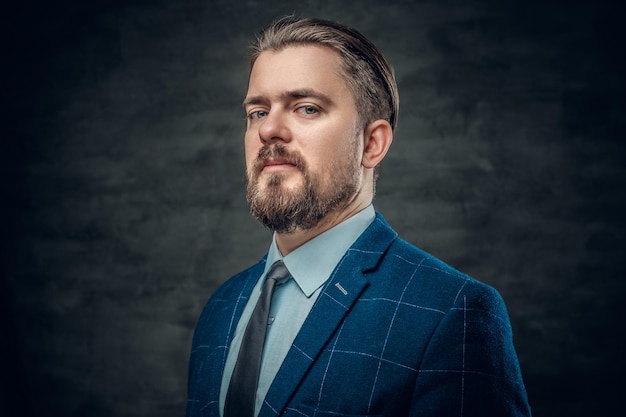 Retrato de un elegante hombre barbudo vestido con chaqueta de lana y pajarita.