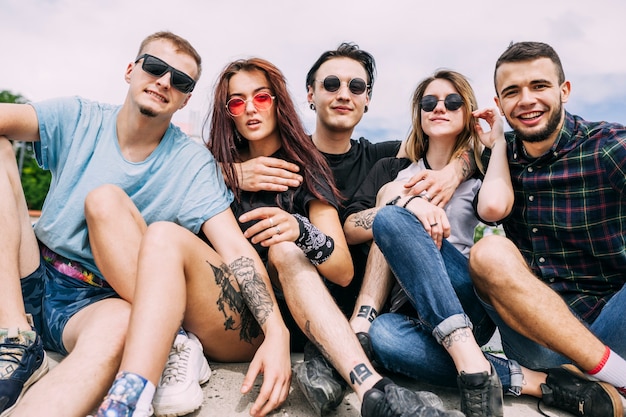 Foto gratuita retrato de elegantes jóvenes amigos sentados juntos