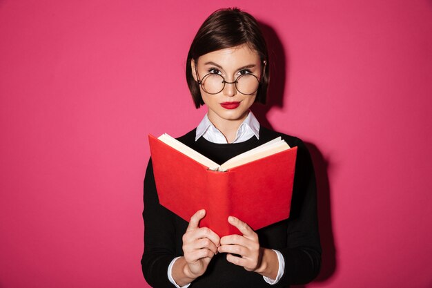 Retrato de una empresaria atractiva sonriente leyendo un libro