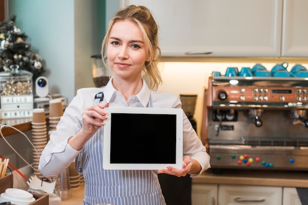 Retrato de una empresaria mostrando pizarra en blanco en la cafetería