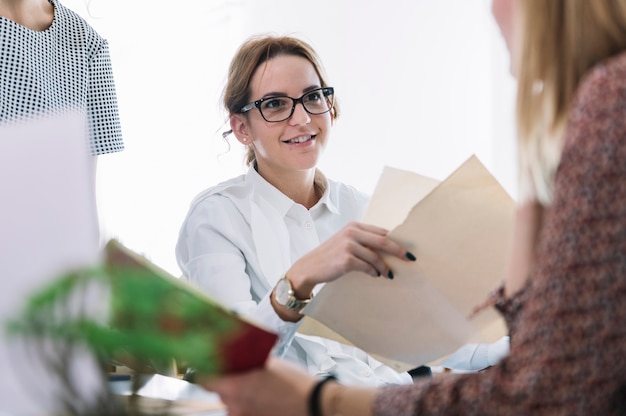 Foto gratuita retrato de la empresaria sonriente que se sienta con su colega