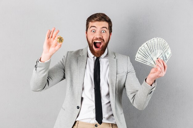 Retrato de un empresario excitado mostrando bitcoin