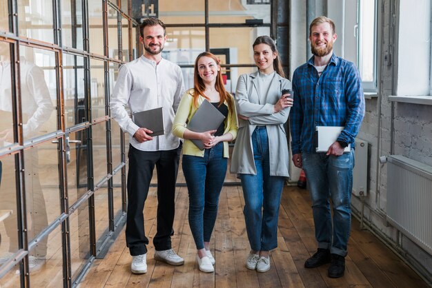 Retrato de los empresarios sonrientes que se colocan en oficina