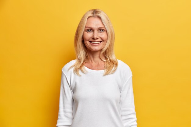 Retrato de encantadora mujer atractiva de mediana edad con cabello rubio