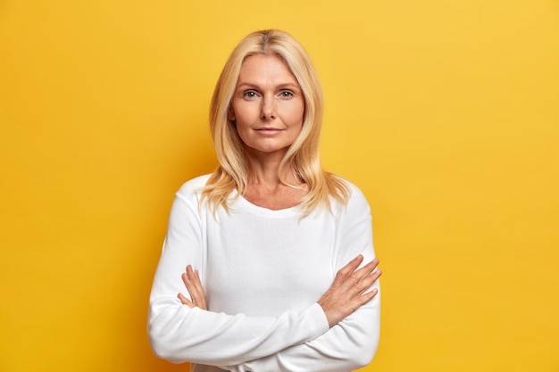 Retrato de encantadora mujer atractiva de mediana edad con cabello rubio