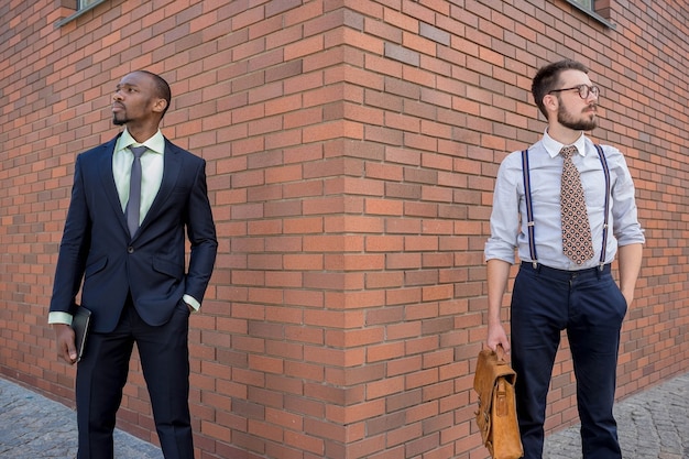 Retrato de equipo de negocios multiétnico. Dos hombres de pie con el telón de fondo de la ciudad. Un hombre es afroamericano, el otro es europeo. concepto de éxito empresarial