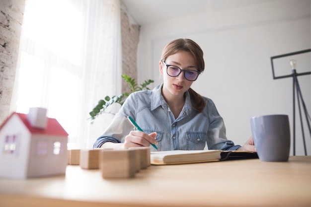 Retrato de una escritura femenina del arquitecto en el libro en el lugar de trabajo