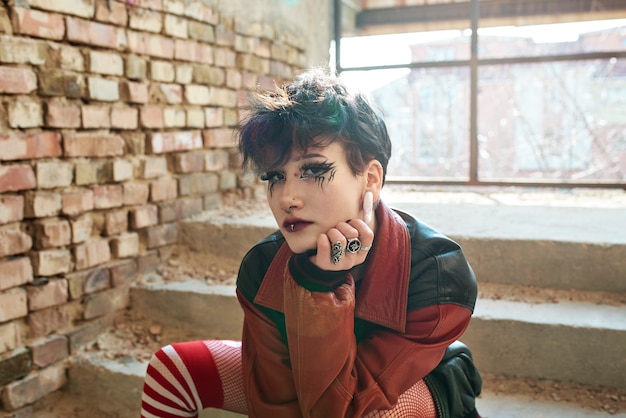 Retrato estético pop punk de mujer posando dentro del edificio en las escaleras