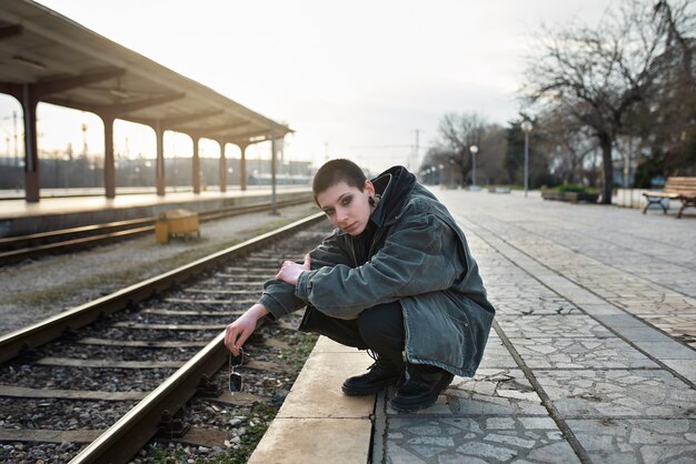 Retrato estético pop punk de mujer posando en la estación de tren