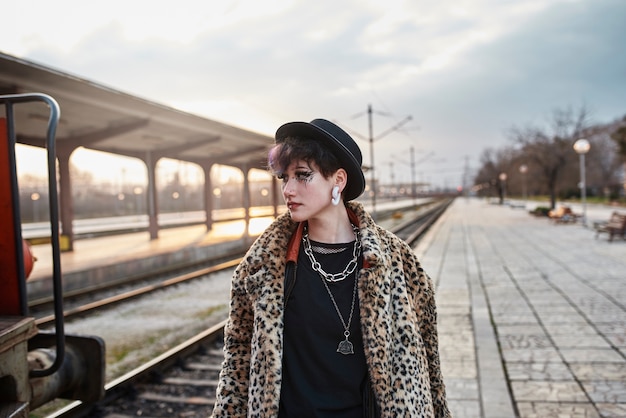 Retrato estético pop punk de mujer posando en la estación de tren