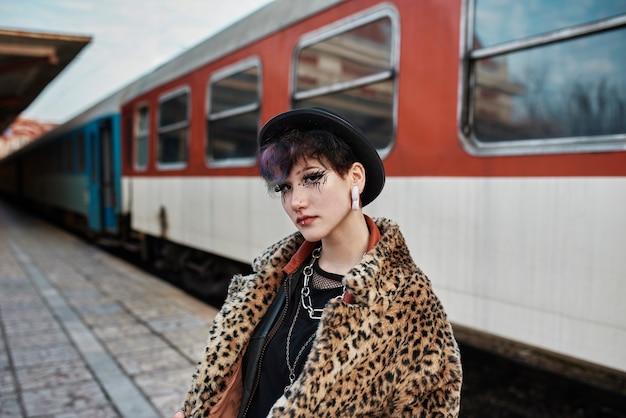 Foto gratuita retrato estético pop punk de mujer posando junto a una locomotora