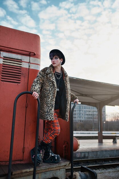 Retrato estético pop punk de mujer posando en locomotora