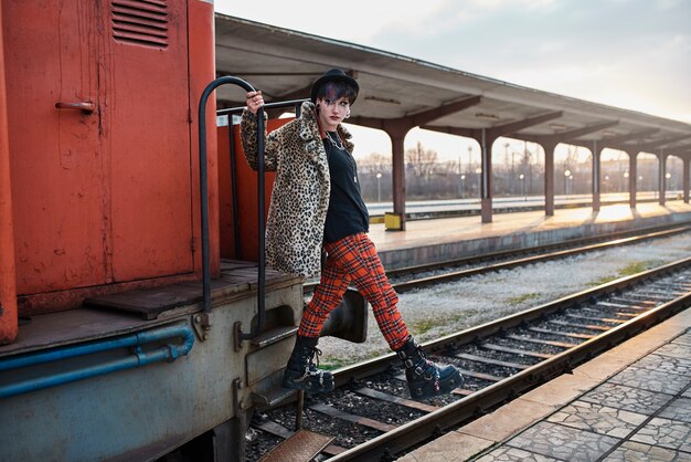Retrato estético pop punk de mujer posando en locomotora