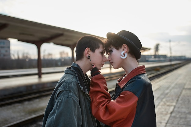 Retrato estético pop punk de mujeres posando en la estación de tren