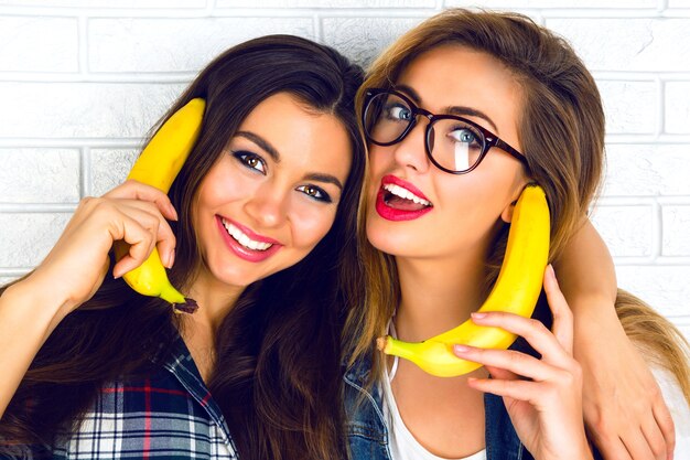 Retrato de estilo de vida de dos bonitas amigas adolescentes sonriendo abrazos y divirtiéndose