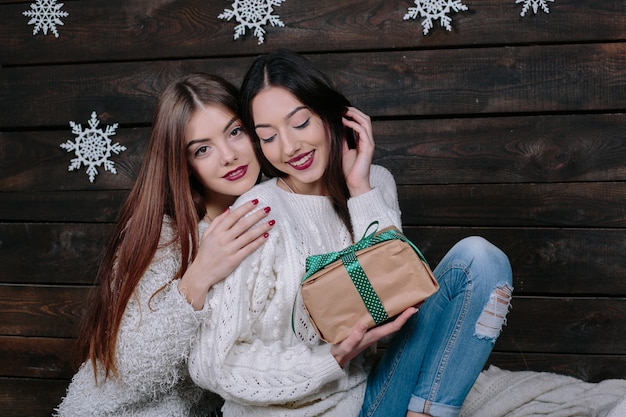 Foto gratuita retrato de estilo de vida interior de dos amigas divertidas bastante jóvenes abrazos sonriendo