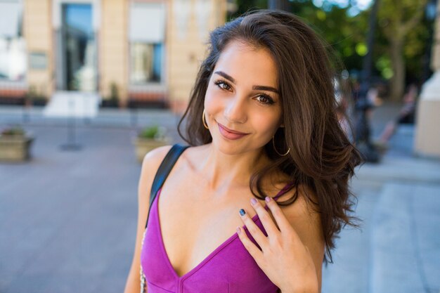 Retrato de estilo de vida de mujer morena feliz en vestido elegante. Alegre joven divirtiéndose, disfrutando de las vacaciones de verano y fines de semana.