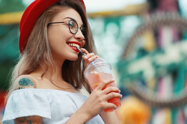 Retrato de estilo de vida de mujer muy elegante bebiendo cócteles