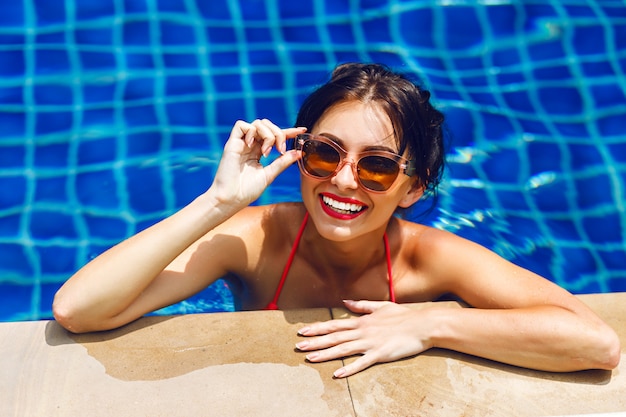 Foto gratuita retrato de estilo de vida de verano de mujer sexy belleza impresionante nadando en la piscina, tomando el sol y relajarse, vacaciones de lujo.