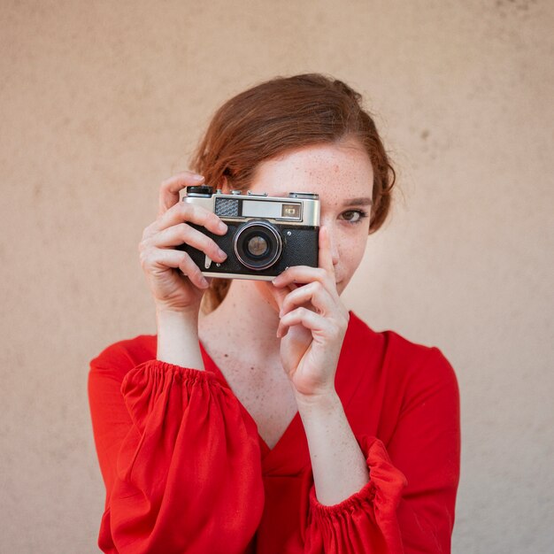 Retrato de estilo vintage de una mujer sosteniendo una cámara
