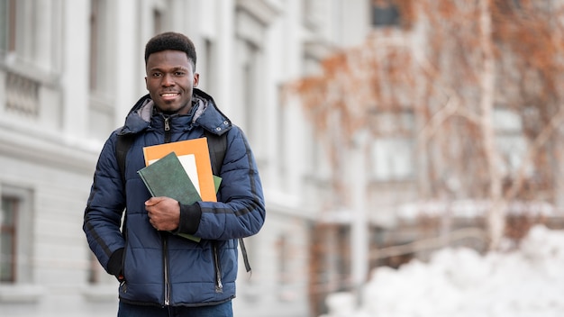 Foto gratuita retrato de estudiante masculino con libros