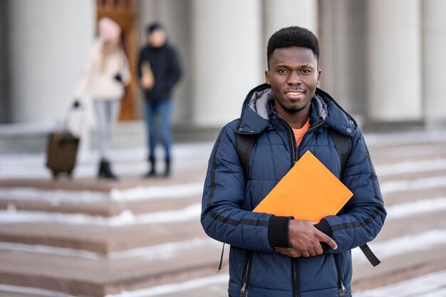 Retrato de estudiante masculino con libros