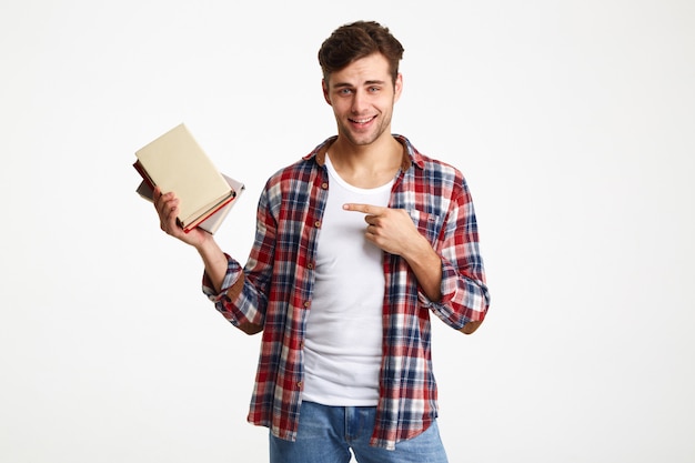 Retrato de un estudiante masculino sonriente que sostiene los libros